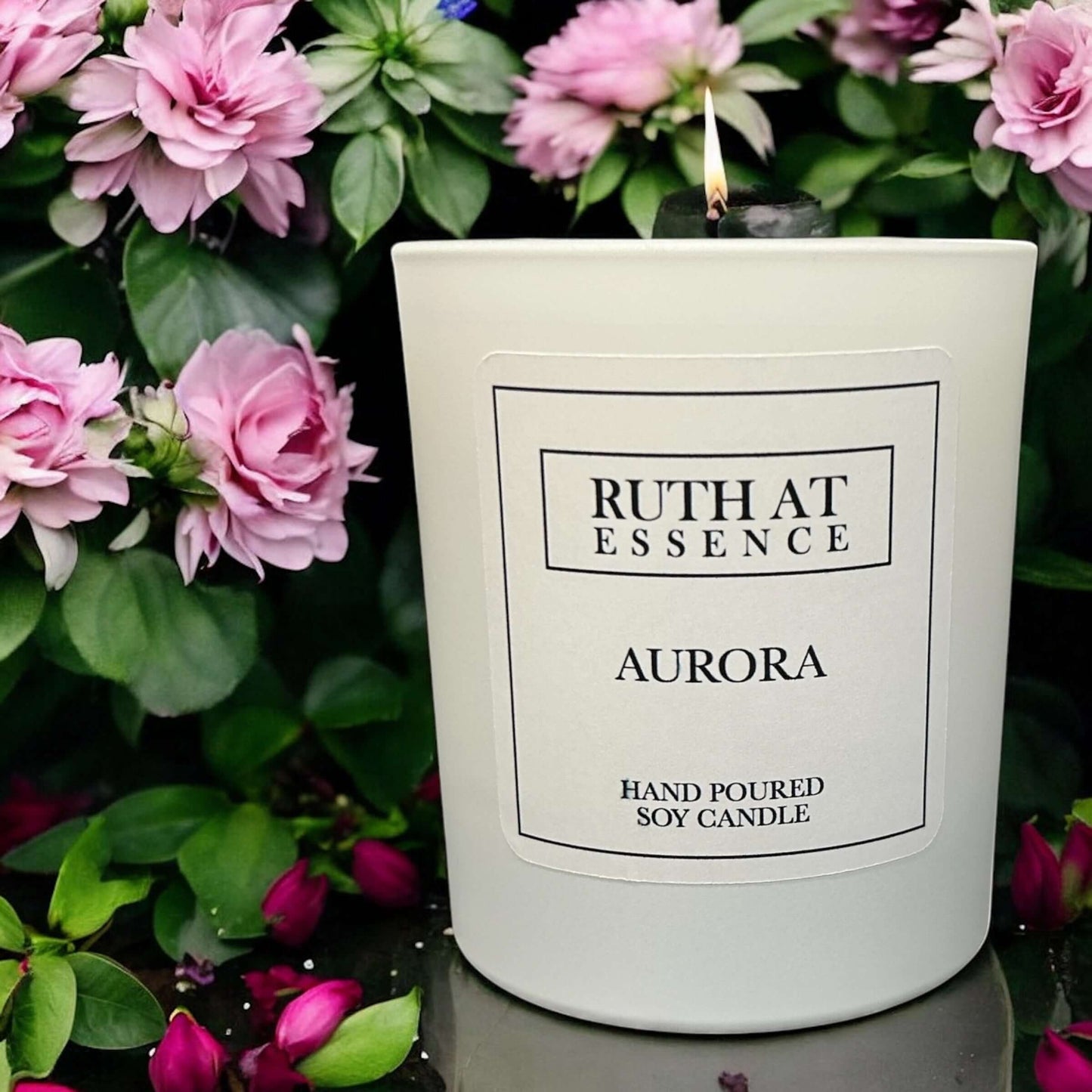 Handmade Aurora candle 220g displayed among pink flowers, vegan friendly and hand poured soy wax.