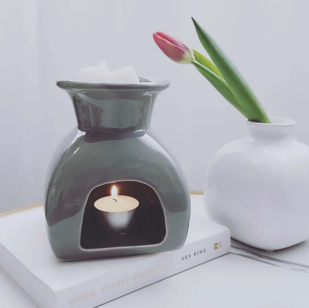 Grey Wax Melt Burner with a lit tea light candle and wax melts, enhancing home fragrance decor.