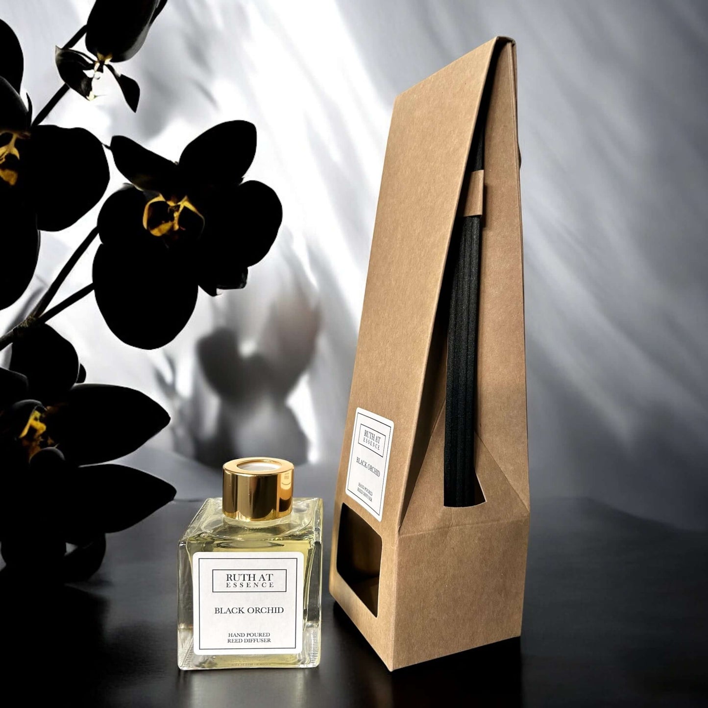 Handmade Black Orchid Reed Diffuser 100ml in elegant packaging with black reed sticks, set against orchid backdrop.