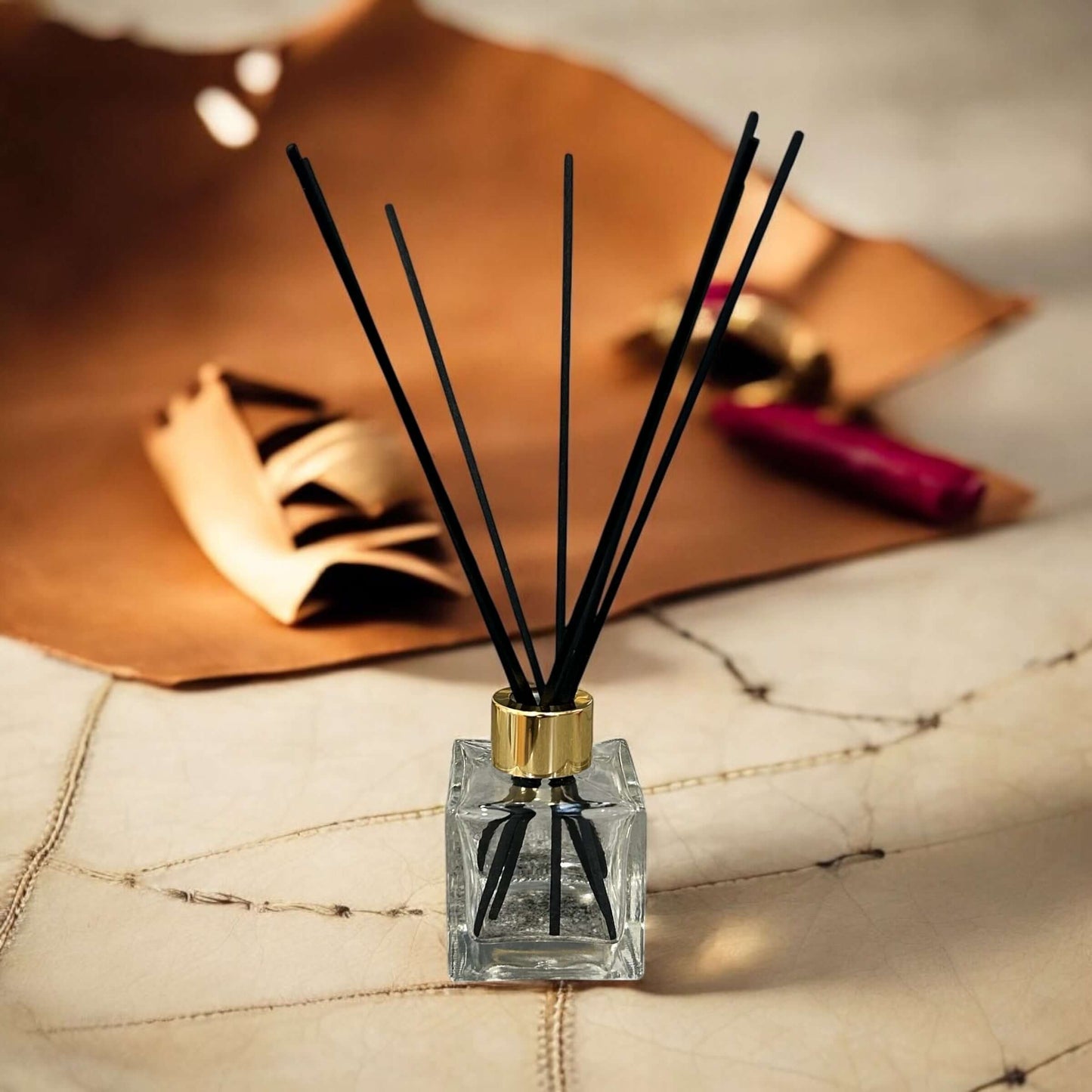 Handmade cigar lounge reed diffuser refill 100ml with black reeds, vegan-friendly fragrance on a stylish surface.