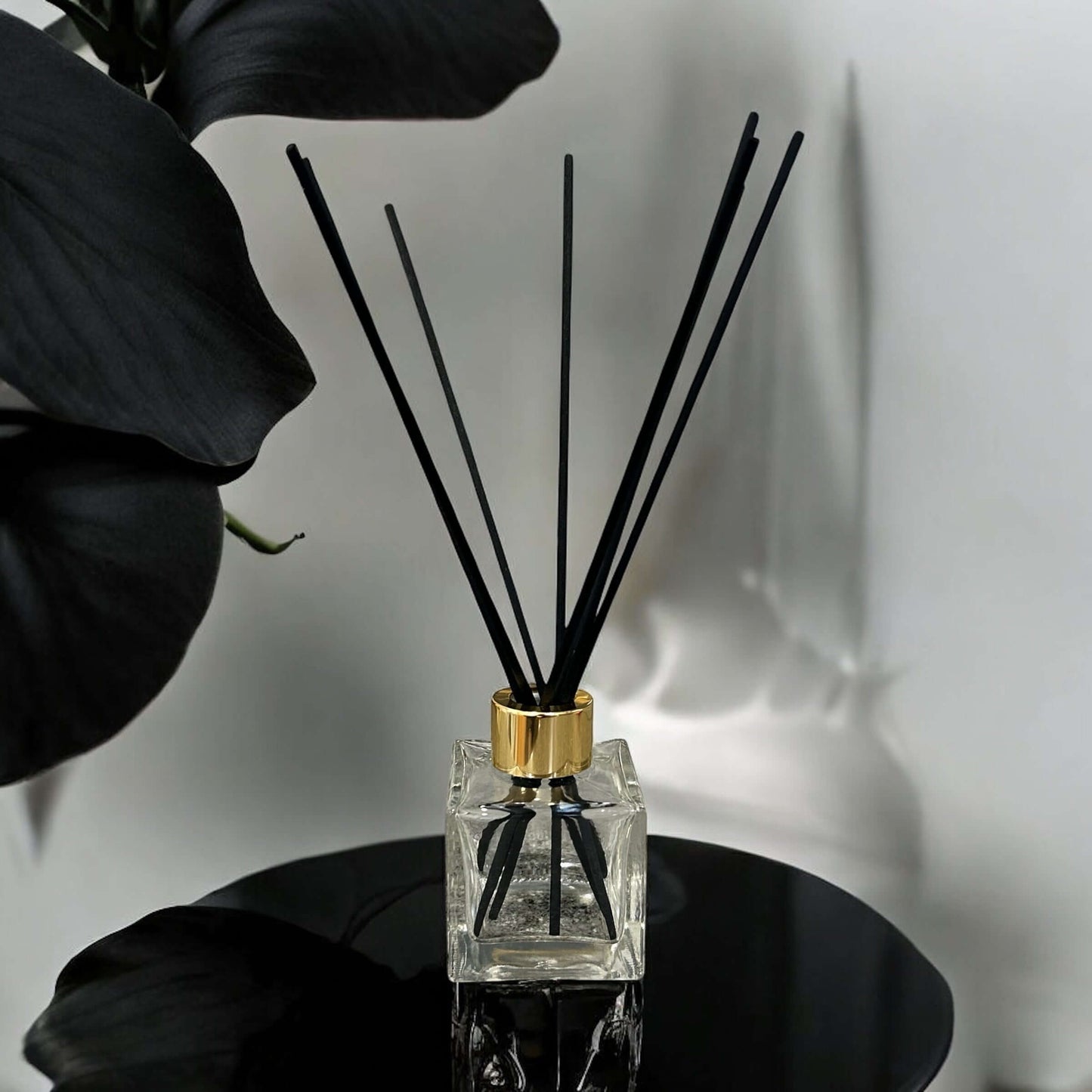 Handmade black orchid reed diffuser in a glass jar with black sticks, adding luxurious fragrance to any space.