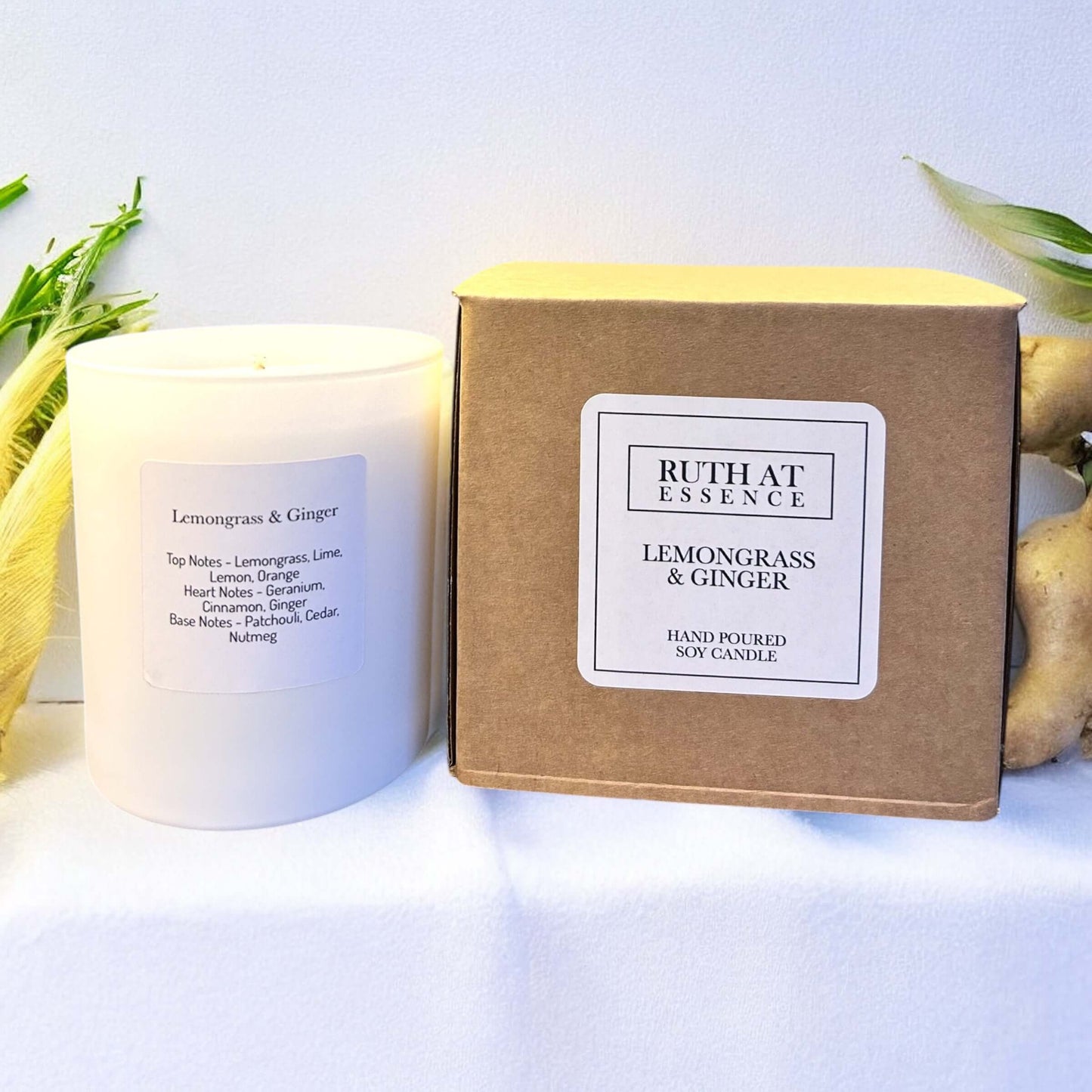 Handmade Lemongrass & Ginger candle in a stylish white jar next to its eco-friendly packaging.