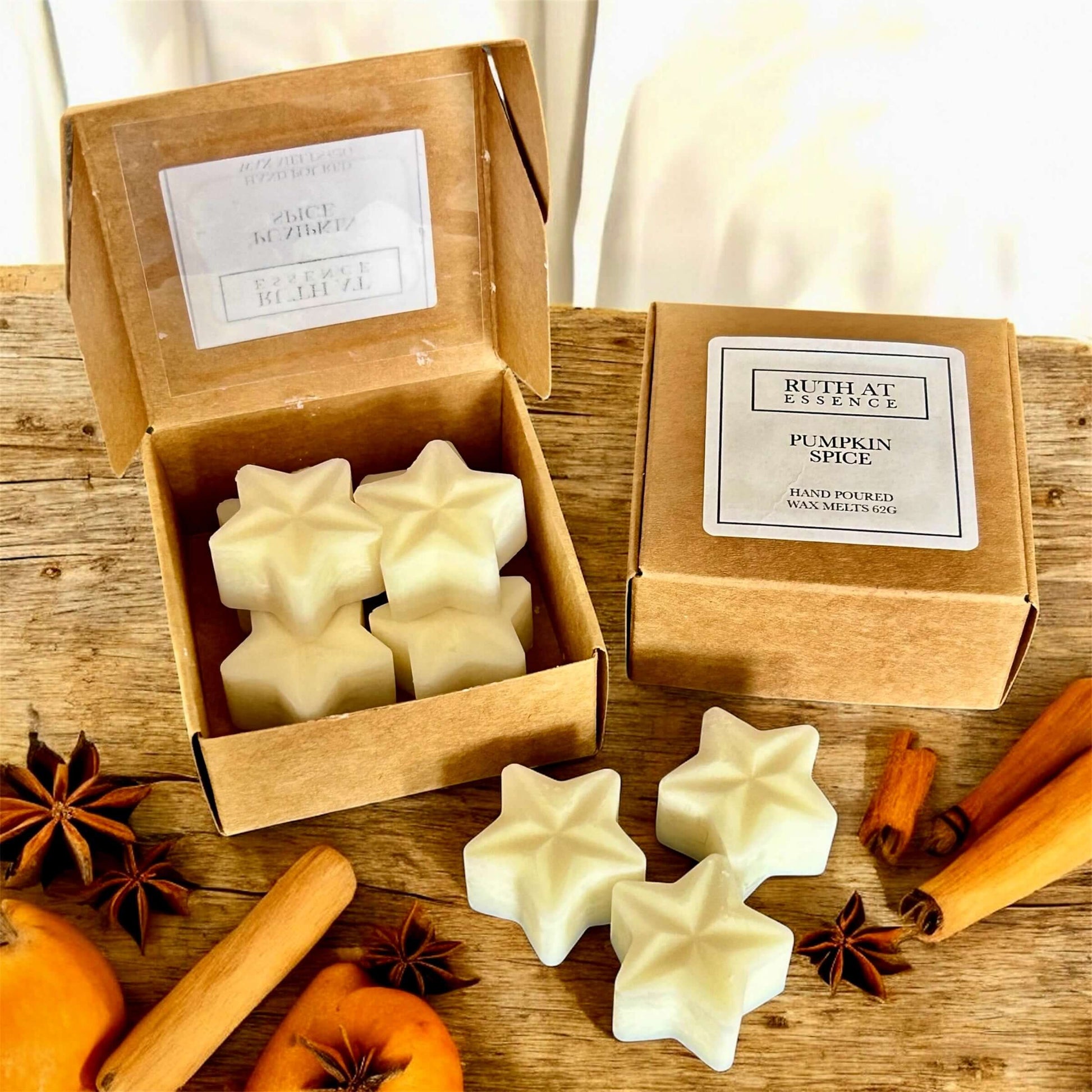 Pumpkin Spice Wax Melts in star shapes, packaged in a box, surrounded by spices and autumn decor.