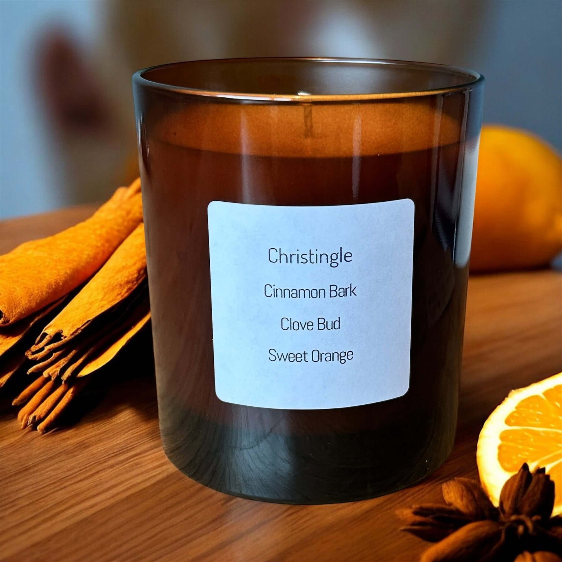 Christingle candle featuring cinnamon bark, clove bud, and sweet orange in a stylish glass container.