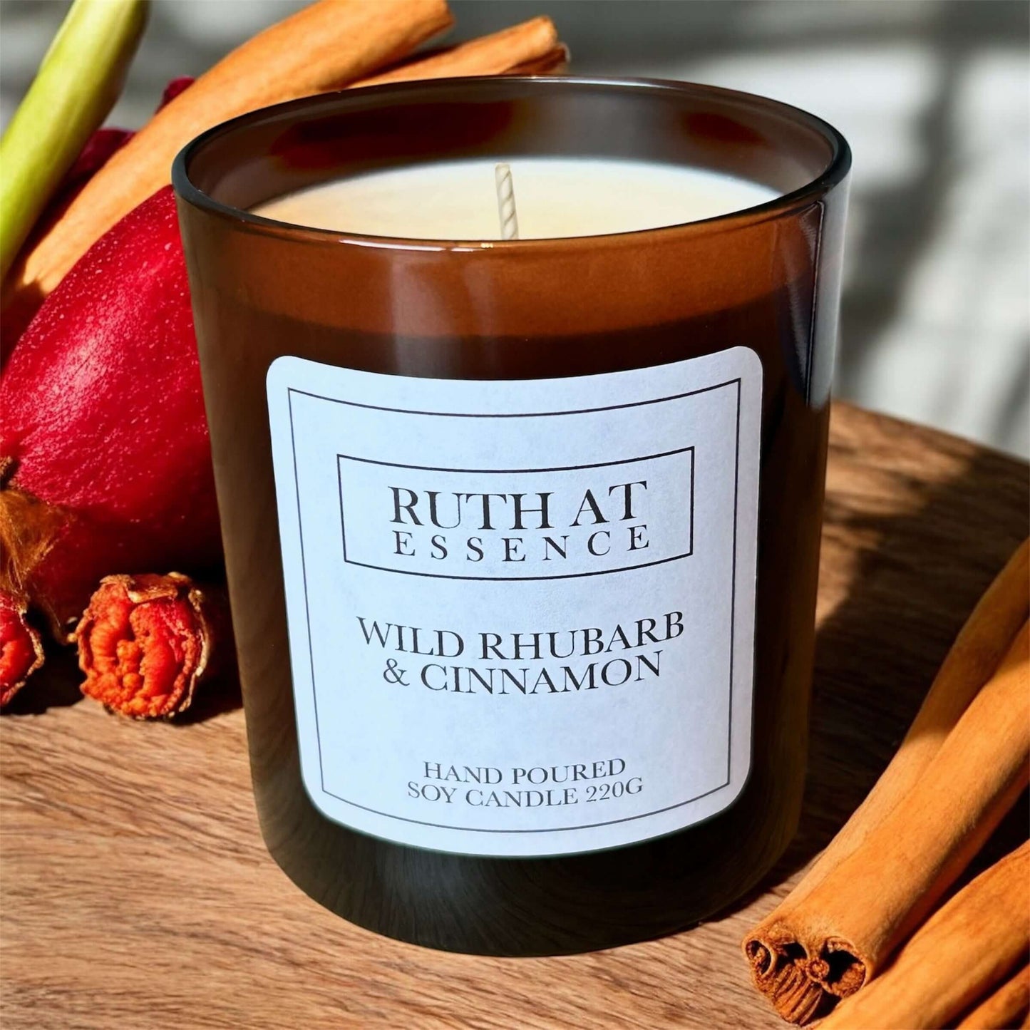 Wild Rhubarb & Cinnamon Candle in amber jar with spice accents, perfect for creating winter warmth.