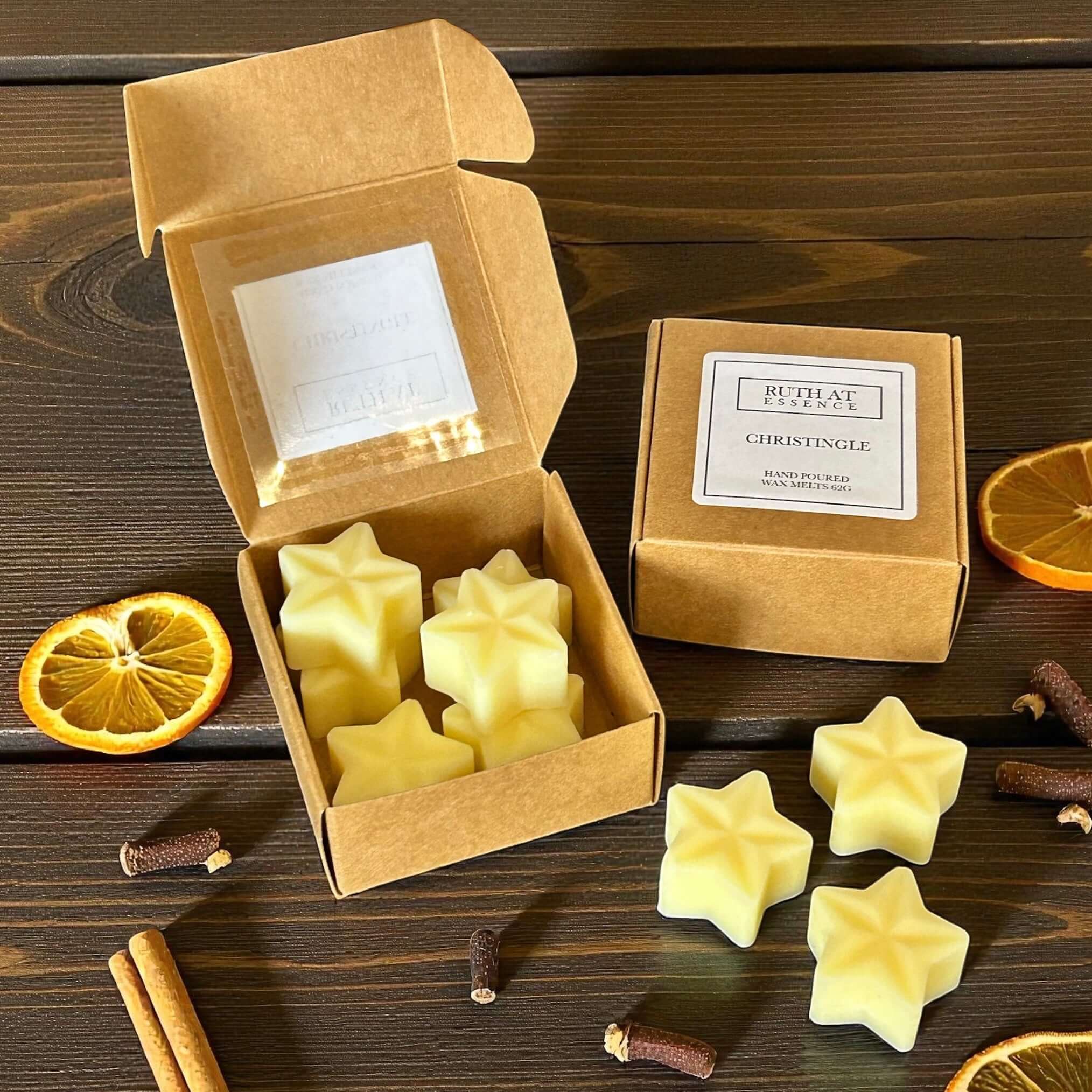 Christingle wax melts in star shapes, displayed in eco-friendly packaging with cinnamon and orange slices.